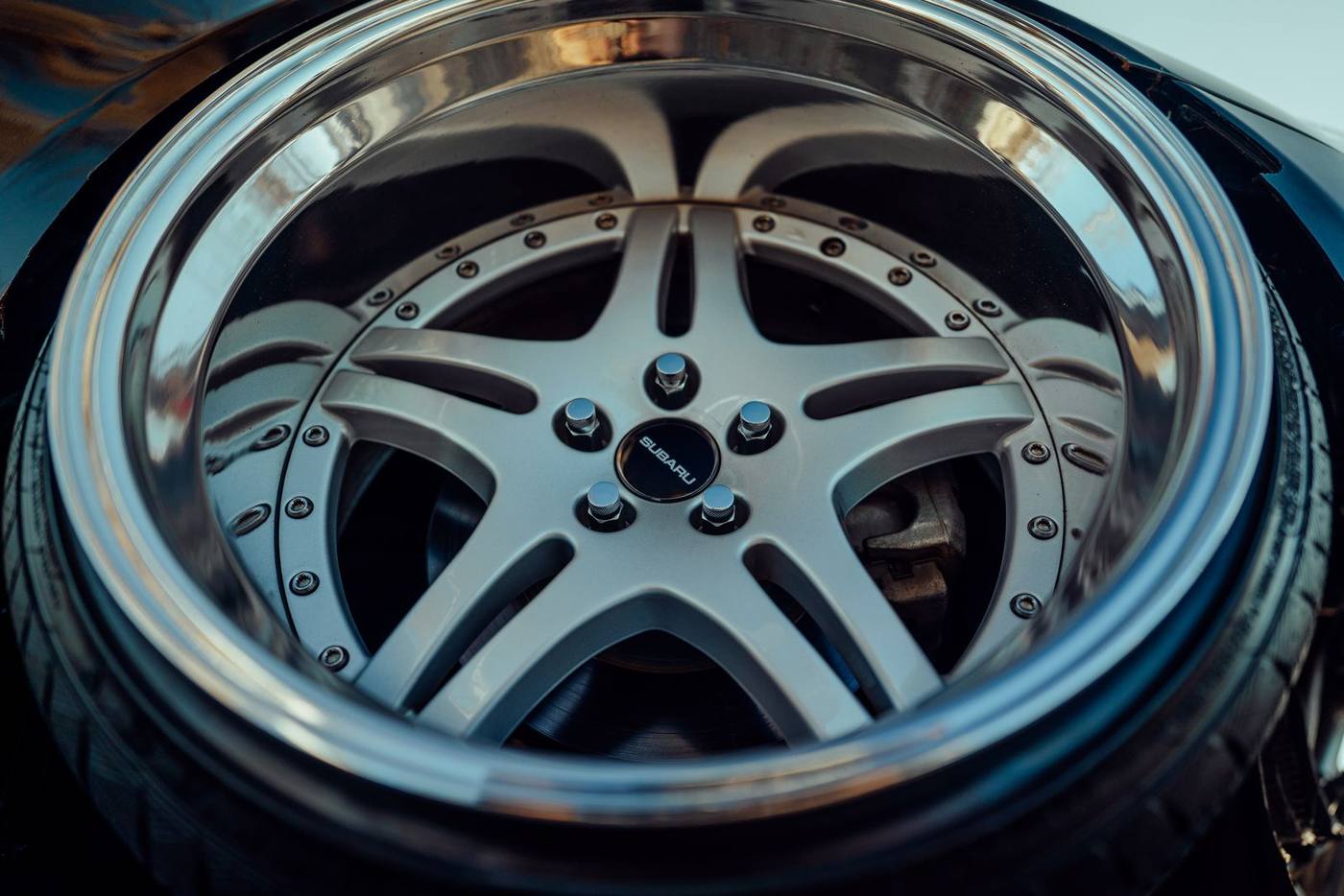 Silver alloy wheel with a polished outer lip, in good condition, a different wheel from the scuffed steel rim